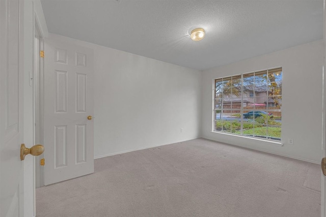 carpeted spare room featuring a textured ceiling