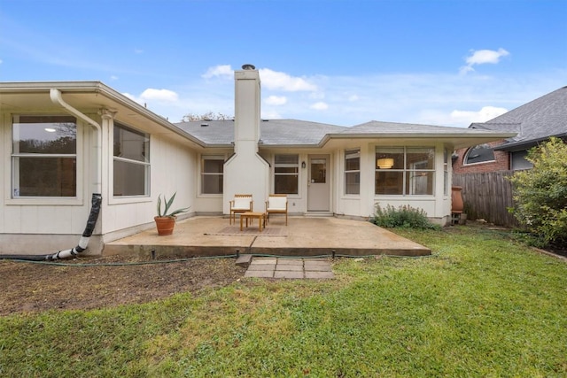 back of house featuring a lawn and a patio