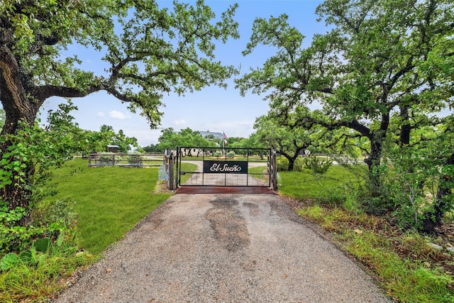 view of gate with a yard