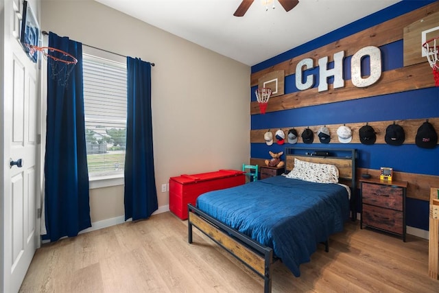 bedroom with light wood-style flooring, baseboards, and a ceiling fan