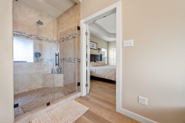 full bathroom with a shower stall, baseboards, connected bathroom, and wood finished floors