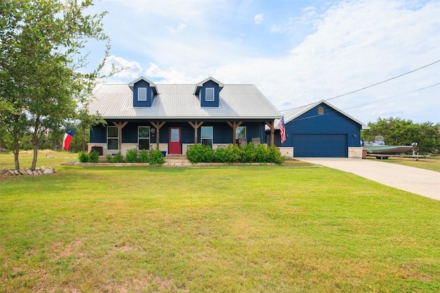 view of front facade featuring a porch, a front yard, metal roof, and a garage