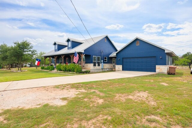 view of front of property featuring a porch, a garage, and a front yard