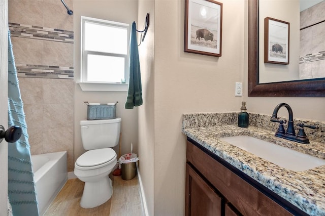 full bath with toilet, shower / bath combo with shower curtain, vanity, wood finished floors, and baseboards