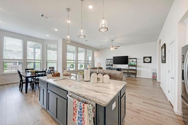 kitchen featuring visible vents, light wood-style flooring, a sink, stainless steel appliances, and a wealth of natural light