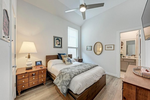 bedroom featuring lofted ceiling, ceiling fan, connected bathroom, baseboards, and light wood-type flooring