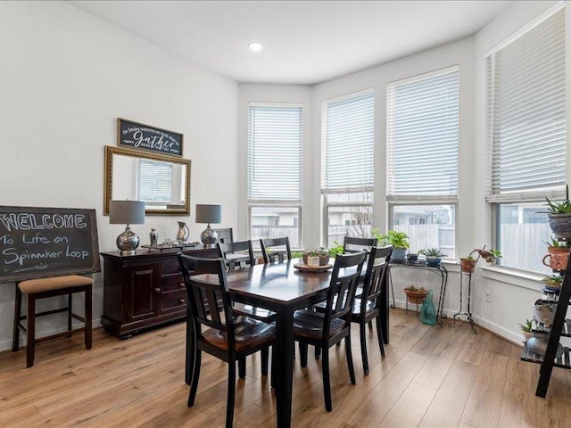 dining space with light wood finished floors and baseboards