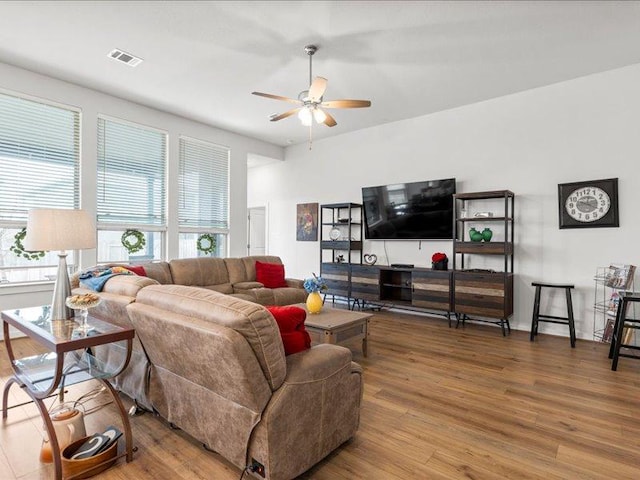 living area with ceiling fan, visible vents, and wood finished floors