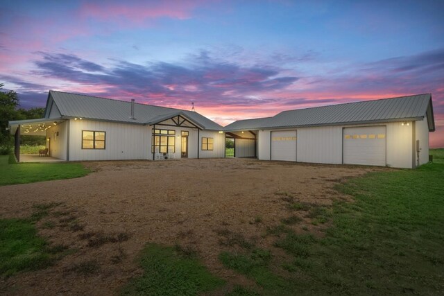 back house at dusk featuring a garage