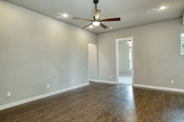 empty room featuring dark hardwood / wood-style flooring, a wealth of natural light, and ceiling fan