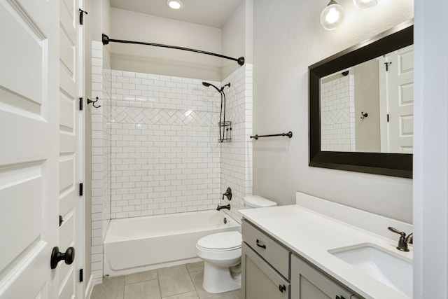 full bathroom featuring tile patterned flooring, vanity, tiled shower / bath, and toilet