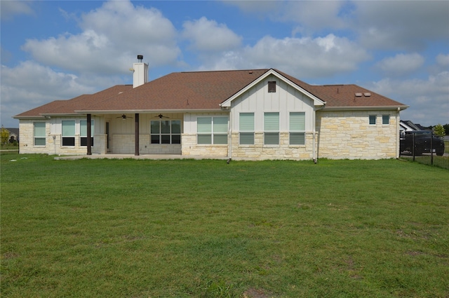 back of property featuring a lawn and ceiling fan