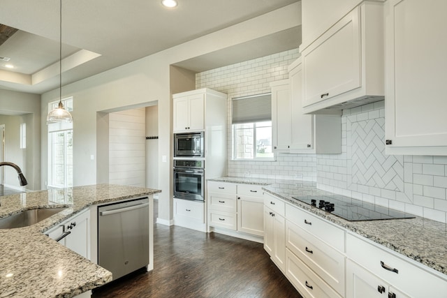 kitchen with sink, white cabinetry, pendant lighting, stainless steel appliances, and backsplash