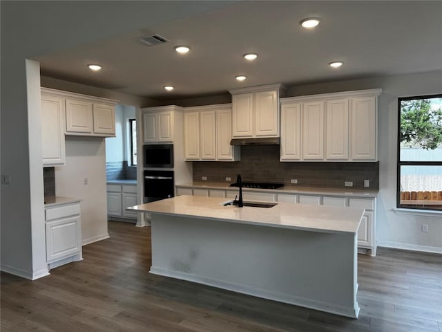 kitchen with oven, white cabinetry, and dark wood-type flooring