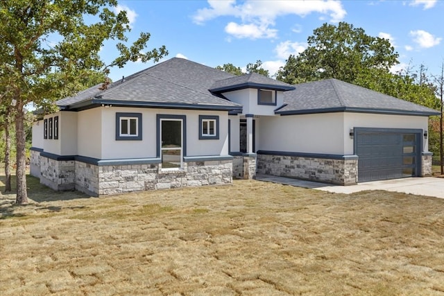 prairie-style house with a garage and a front lawn