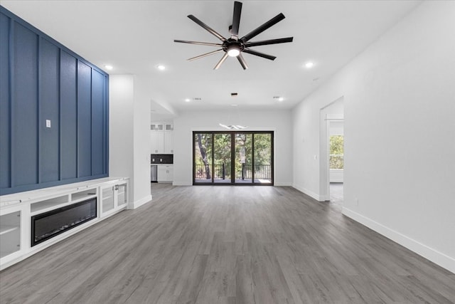 unfurnished living room featuring ceiling fan, hardwood / wood-style flooring, and plenty of natural light