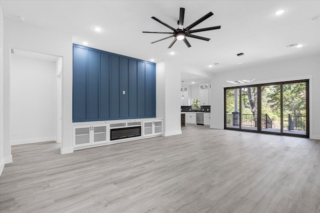 unfurnished living room featuring ceiling fan and light hardwood / wood-style floors