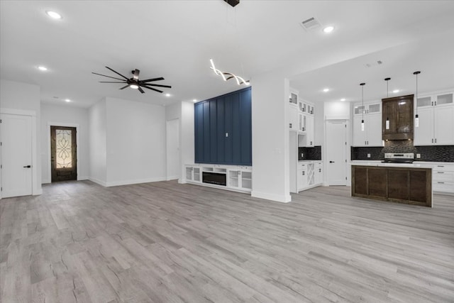 unfurnished living room featuring light wood-type flooring and ceiling fan