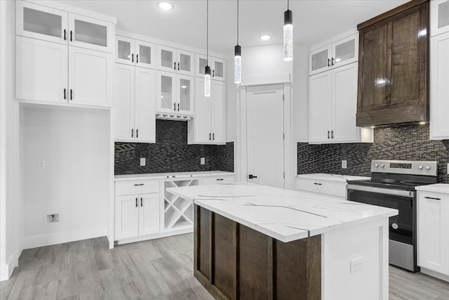 kitchen with a center island, white cabinetry, and stainless steel range with electric stovetop