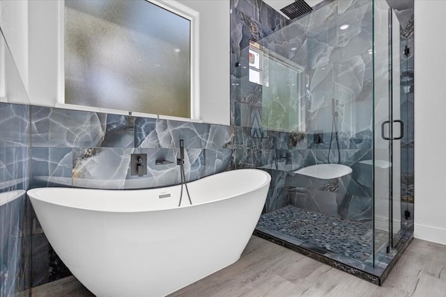 bathroom featuring tile walls, hardwood / wood-style floors, and independent shower and bath