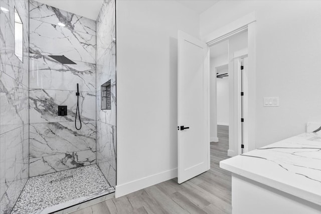 bathroom with hardwood / wood-style floors and tiled shower