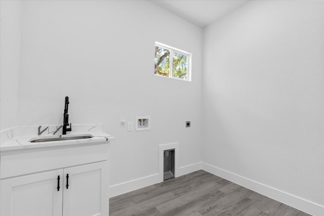 laundry room with hookup for a washing machine, light hardwood / wood-style floors, electric dryer hookup, and sink