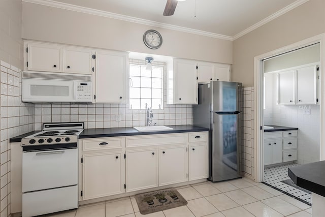 kitchen with sink, white appliances, light tile patterned floors, and white cabinets