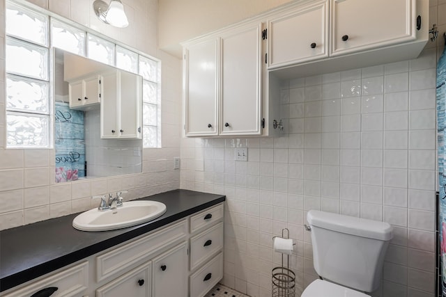 bathroom with vanity, a wealth of natural light, tile walls, and toilet