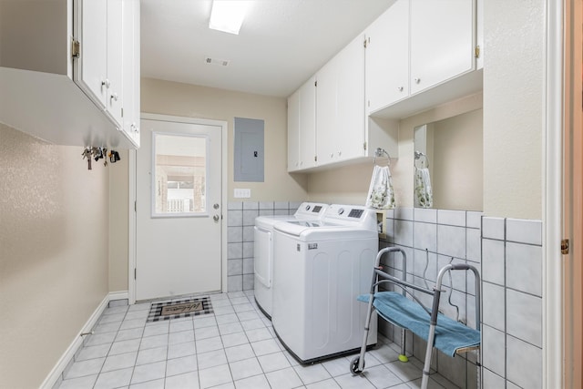 laundry room featuring light tile patterned flooring, cabinets, tile walls, electric panel, and independent washer and dryer