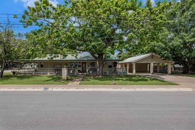 view of front facade featuring a carport, a porch, and a front lawn