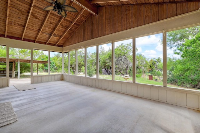 unfurnished sunroom with vaulted ceiling with beams, wood ceiling, a ceiling fan, and a healthy amount of sunlight