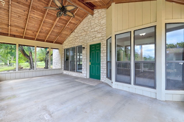 unfurnished sunroom featuring vaulted ceiling with beams, wood ceiling, and ceiling fan