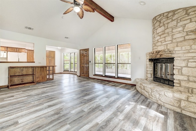 unfurnished living room featuring beam ceiling, a fireplace, wood-type flooring, and ceiling fan