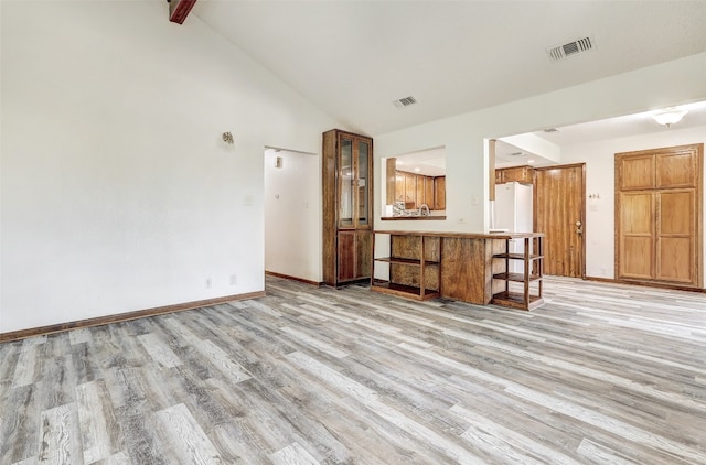 unfurnished living room featuring light hardwood / wood-style flooring and high vaulted ceiling