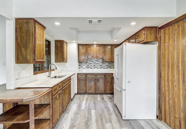 kitchen with light hardwood / wood-style floors, white appliances, sink, and a textured ceiling