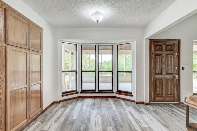 interior space featuring a textured ceiling and light wood-type flooring