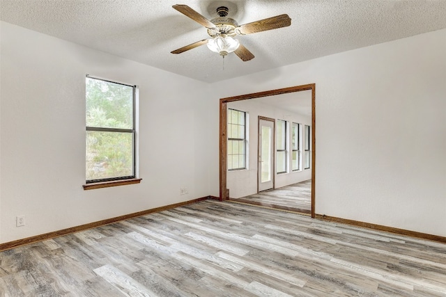 spare room with ceiling fan, a textured ceiling, and light hardwood / wood-style flooring