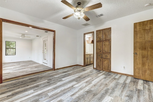 unfurnished room with light hardwood / wood-style floors, a textured ceiling, and ceiling fan