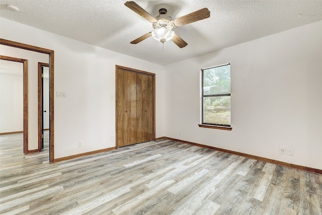 spare room with light hardwood / wood-style floors, a textured ceiling, and ceiling fan