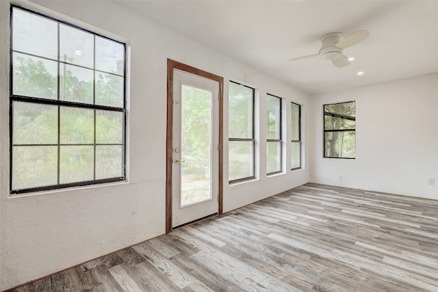 unfurnished sunroom featuring ceiling fan