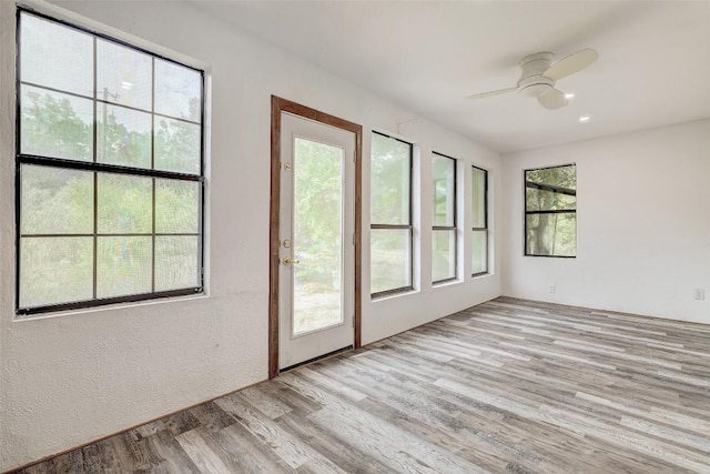 unfurnished sunroom with ceiling fan