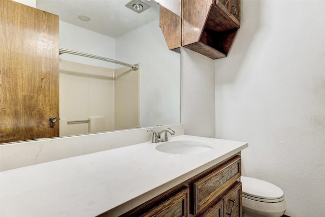 full bath featuring a shower, vanity, and toilet