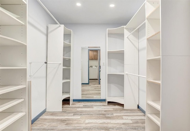 walk in closet with wood finished floors