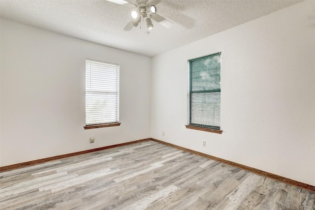 empty room with baseboards, ceiling fan, light wood-style flooring, and a textured ceiling