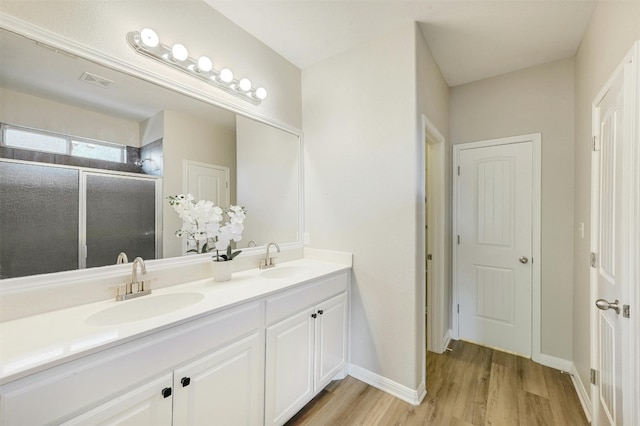 bathroom with vanity, walk in shower, and hardwood / wood-style floors