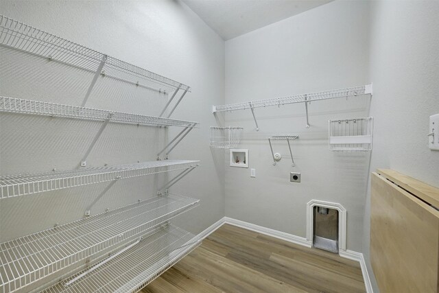 laundry area with electric dryer hookup, hookup for a washing machine, wood-type flooring, and gas dryer hookup