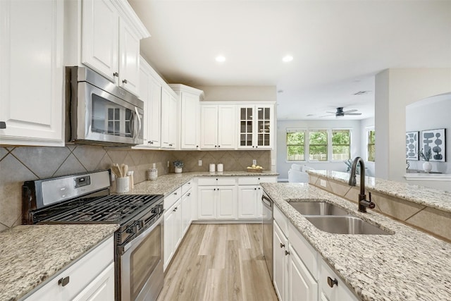 kitchen featuring light hardwood / wood-style floors, sink, white cabinets, appliances with stainless steel finishes, and ceiling fan