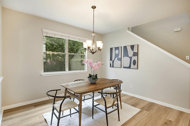 dining space with light wood-type flooring and a chandelier