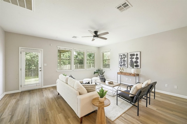 living room with ceiling fan and light hardwood / wood-style flooring