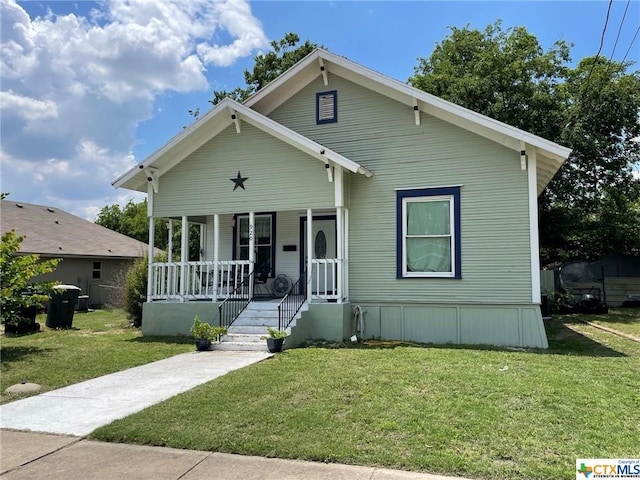 bungalow with a porch and a front lawn